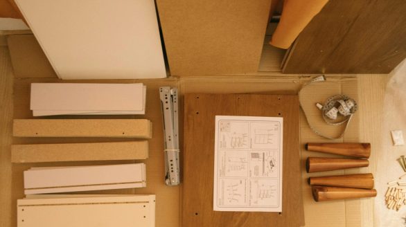 Top view of arranged pieces with instruction paper on carton before assembling furniture at home